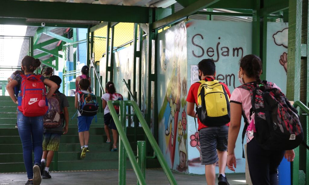 São Paulo - Crianças do ensino fundamental chegam para as aulas presenciais na Escola Estadual Terezine Arantes Ferraz Bibliotecaria, no Parque Casa de Pedra, zona norte da capital.